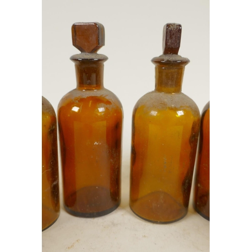 21 - Eight antique amber glass chemist bottles with stoppers, 4½