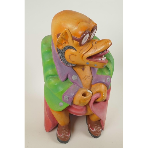 34 - A South East Asian carved wood grotesque figure in brightly painted clothing, 16½