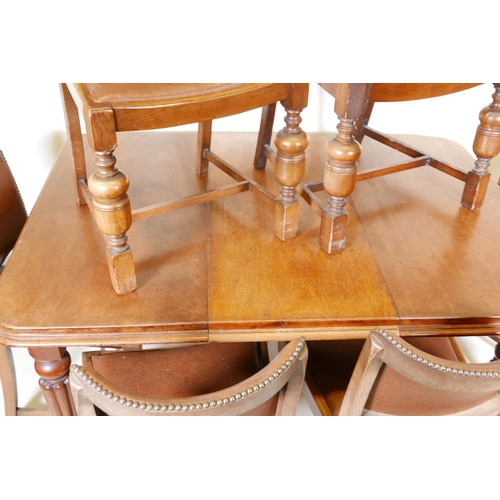 1147 - A Victorian mahogany wind out dining table on turned and carved legs, with a single leaf, and six oa... 