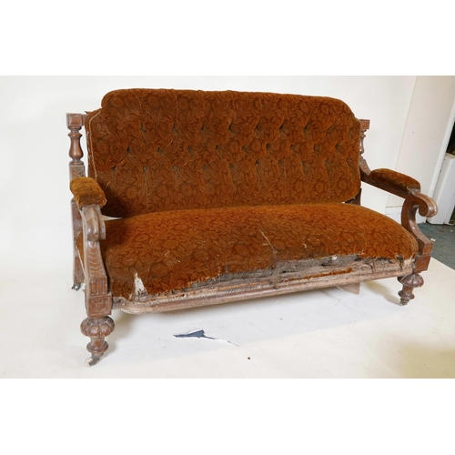 1134 - A C19th walnut frame settee with carved open arms, raised on gadrooned front feet and sabre back leg... 