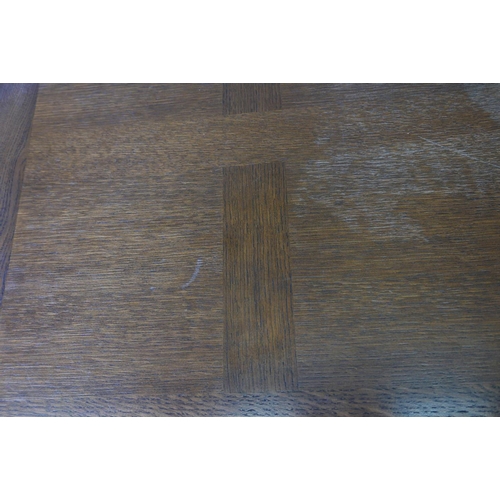 1137 - A French oak drawleaf dining table, with parquetry veneered top and pull out leaves, raised on cabri... 