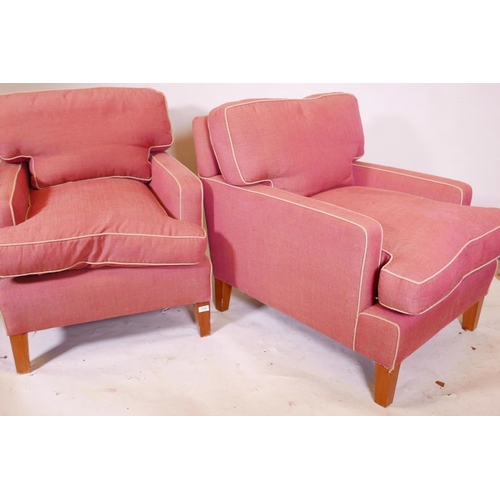 1254 - A pair of deep back contemporary armchairs, raised on tapering supports, each with a footstool, mino... 