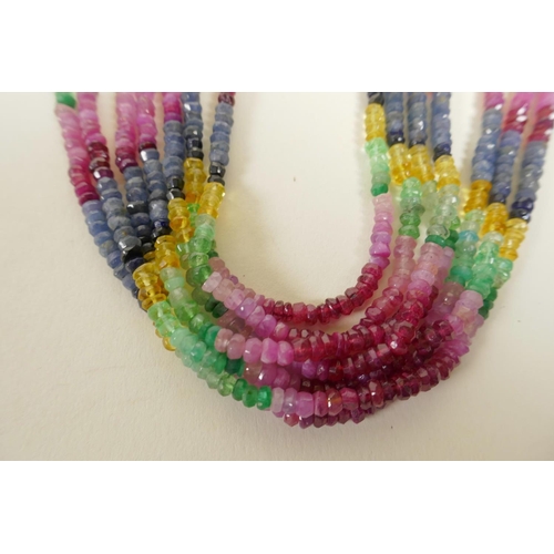 722 - A seven strand ruby, emerald and blue sapphire gemstone necklace, with gold and coloured silk thread