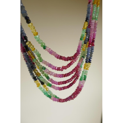 722 - A seven strand ruby, emerald and blue sapphire gemstone necklace, with gold and coloured silk thread