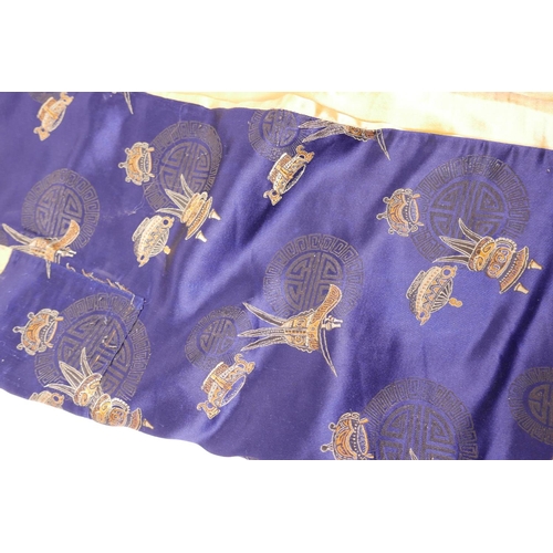 10 - A Chinese blue silk robe decorated with auspicious symbols and assorted vessels, 50