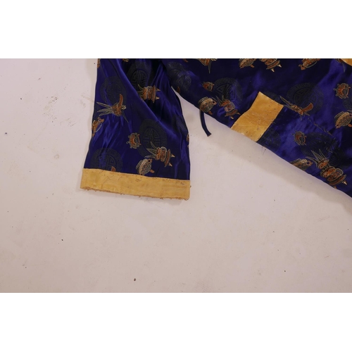 10 - A Chinese blue silk robe decorated with auspicious symbols and assorted vessels, 50