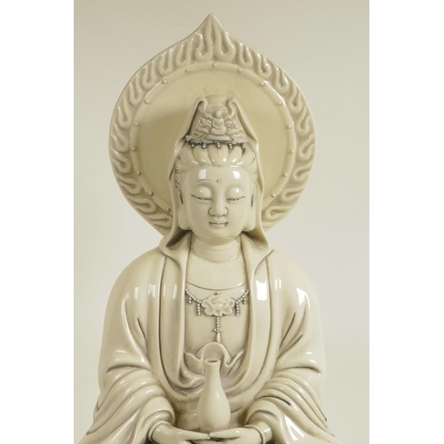 100 - A Chinese blanc de chine figure of Quan Yin seated on a lotus throne, seal marks verso, 20