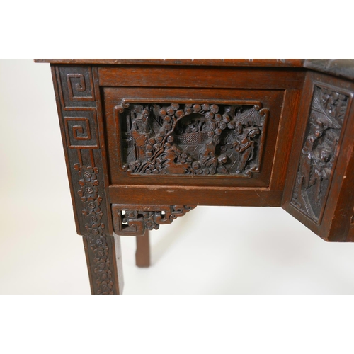 1003 - A Chinese carved hardwood desk, the raised upper section with two small cupboards and pigeon holes, ... 