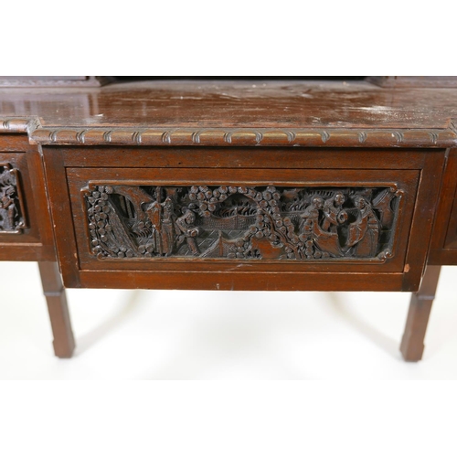 1003 - A Chinese carved hardwood desk, the raised upper section with two small cupboards and pigeon holes, ... 