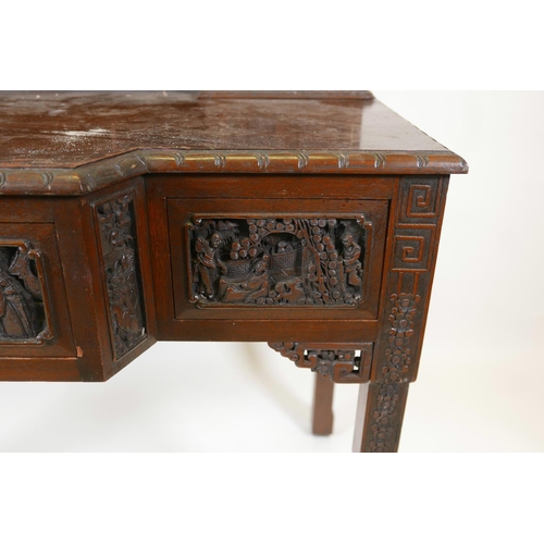 1003 - A Chinese carved hardwood desk, the raised upper section with two small cupboards and pigeon holes, ... 