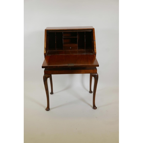 1017 - A Queen Anne style walnut fall front bureau, with fitted interior over single drawer, raised on cabr... 