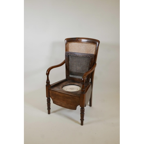 1018 - A beech framed commode armchair with bergere panel back by Carter's Ltd, 39