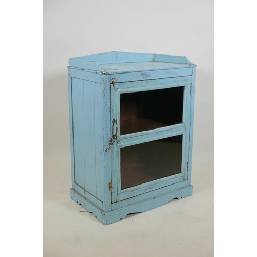 1048 - An Indian painted hardwood cabinet with single glazed door, with three quarter gallery top, raised o... 