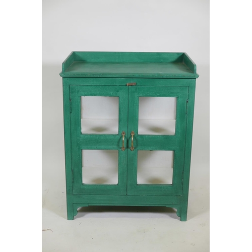 1055 - An Indian painted hardwood two door display cabinet with glazed sides and three quarter gallery top,... 