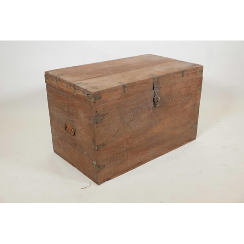 1058 - An Indian teak blanket box, with brass mounts, the interior fitted with a candle box, 30