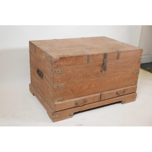 1063 - An Indian teak and brass mounted mule chest with hinged, fold over top and two drawers, raised on a ... 