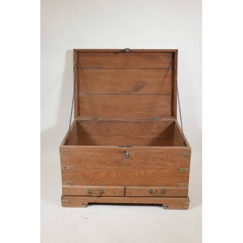 1063 - An Indian teak and brass mounted mule chest with hinged, fold over top and two drawers, raised on a ... 