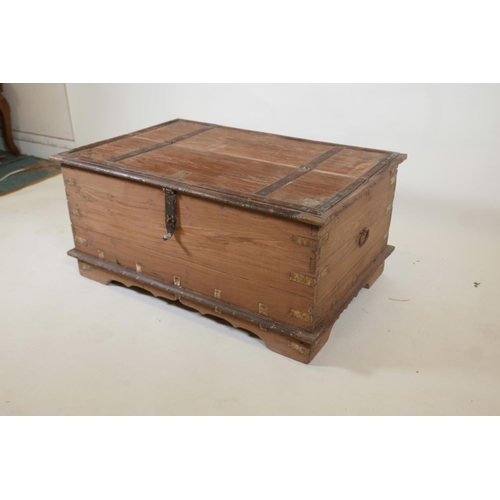 1064 - An Indian teak and brass mounted chest with decorative studs and half hinged fold over top, raised o... 