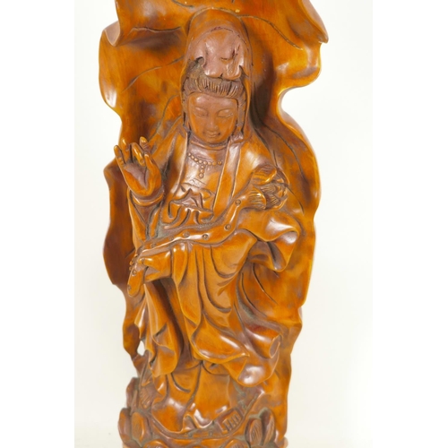 107 - A Chinese carved wood figure of Guan Yin standing on a lotus throne, 20