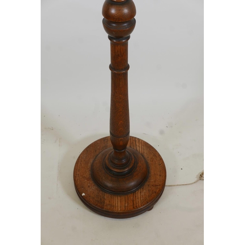 1070 - A carved and turned oak standard lamp, 62