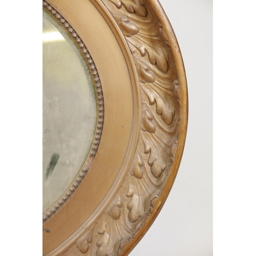 1080 - A C19th oval gilt mirror with a leaf design, 39½