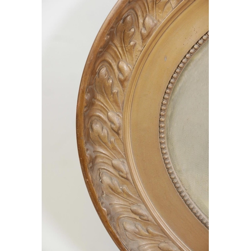 1080 - A C19th oval gilt mirror with a leaf design, 39½