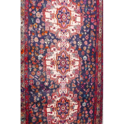 1083 - A Persian thick pile blue ground runner with a multicoloured floral design, 50½