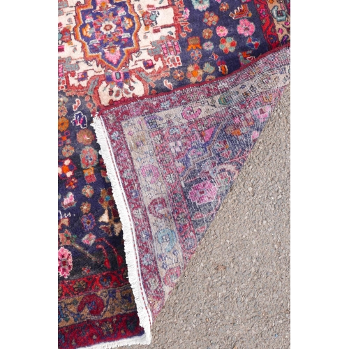 1083 - A Persian thick pile blue ground runner with a multicoloured floral design, 50½