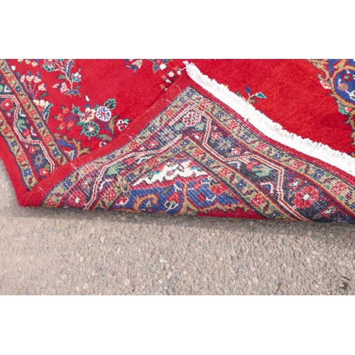 1084 - A Iranian full pile runner with a floral pattern on a rich red ground, 39