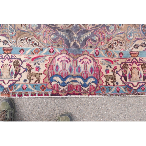 1092 - A vintage Persian Kashmar carpet decorated with a floral medallion on a purple ground, and a cream b... 