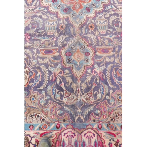 1092 - A vintage Persian Kashmar carpet decorated with a floral medallion on a purple ground, and a cream b... 