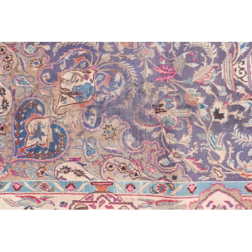 1092 - A vintage Persian Kashmar carpet decorated with a floral medallion on a purple ground, and a cream b... 