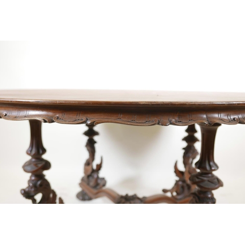 1102 - A late C19th/early C20th walnut coffee table, with carved and shaped edge top, raised on four griffi... 