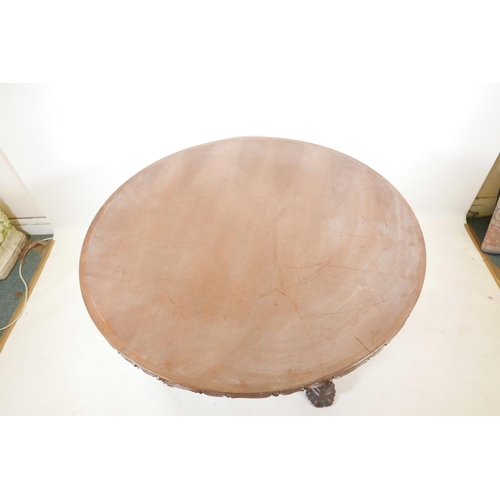 1102 - A late C19th/early C20th walnut coffee table, with carved and shaped edge top, raised on four griffi... 