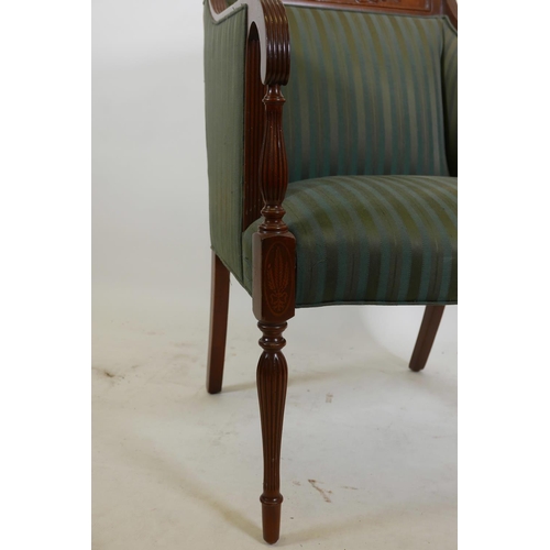 1109 - An Empire style mahogany armchair with carved back rail, reeded arms and tapering supports