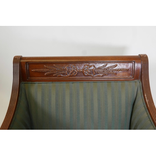 1109 - An Empire style mahogany armchair with carved back rail, reeded arms and tapering supports