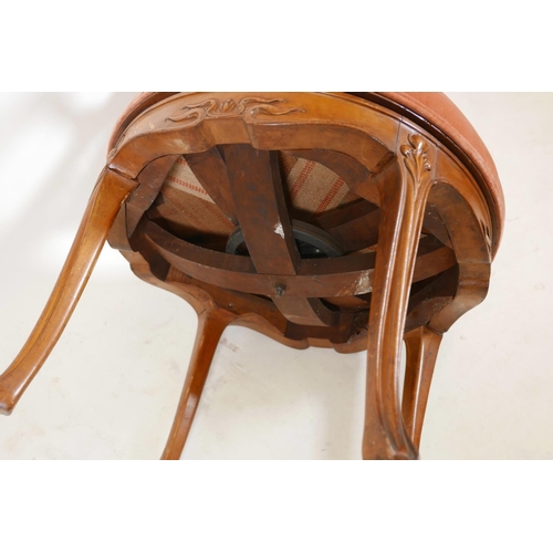 1111 - A C19th Art Nouveau, walnut, tub shaped swivel armchair, with carved and pierced, shaped back, scrol... 