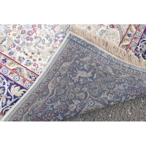 1117 - A cream ground Kashmir rug with a traditional tree of life design and a blue border, 62