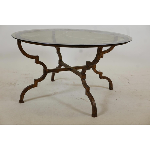 1119 - A gilded steel framed occasional table with shaped supports, cross stretcher and tinted glass top, 3... 