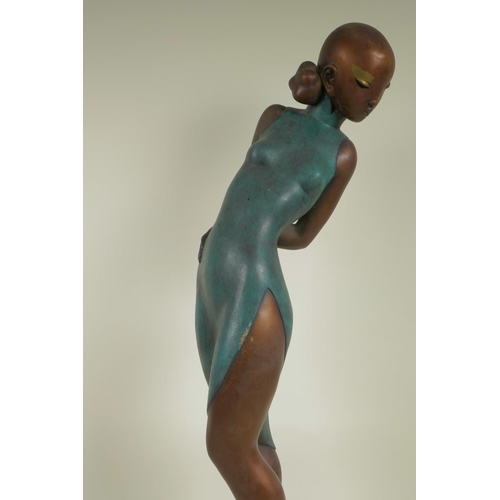 112 - A stylised bronze figurine of a girl in a tight dress, 25½