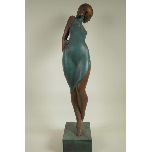 112 - A stylised bronze figurine of a girl in a tight dress, 25½