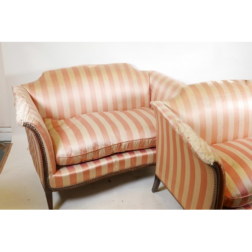 1123 - A pair of two seater settees, with scroll arms and hump backs, raised on reeded tapering supports, A... 