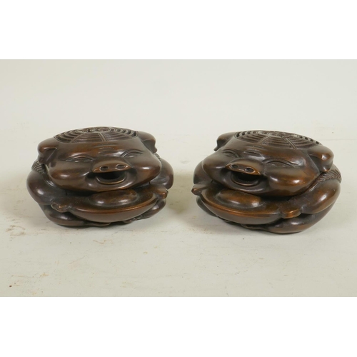 113 - A pair of Chinese bronze incense burners in the form of pigs, with pieced lids decorated with auspic... 