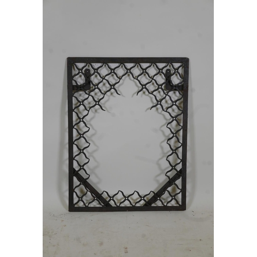 1130 - An Indian wrought iron mirror frame with lattice style decoration, 23