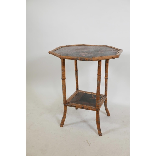 1132 - An Oriental octagonal bamboo occasional table with a lacquer top and undertier decorated with birds ... 