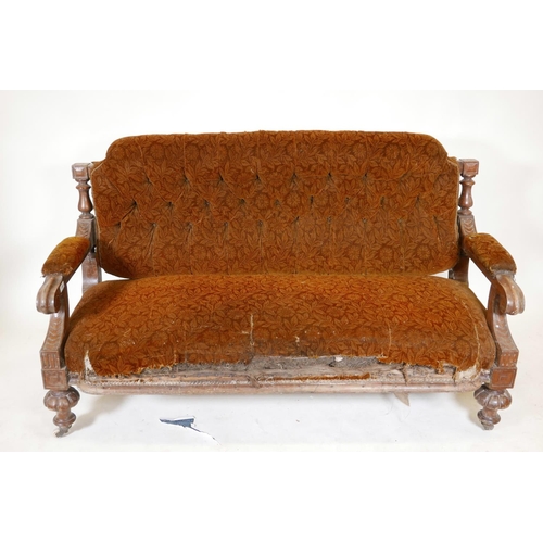 1134 - A C19th walnut frame settee with carved open arms, raised on gadrooned front feet and sabre back leg... 