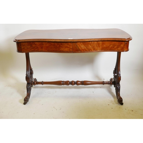 1146 - A good Victorian walnut two drawer stretcher table, with serpentine top, raised on carved and pierce... 