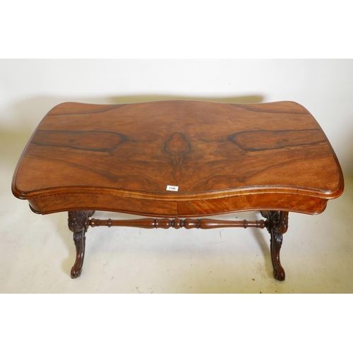 1146 - A good Victorian walnut two drawer stretcher table, with serpentine top, raised on carved and pierce... 