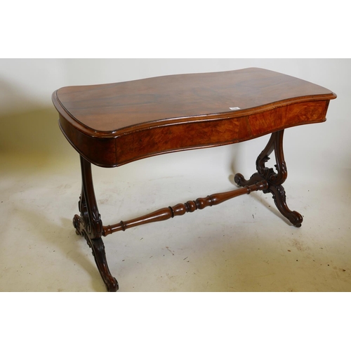 1146 - A good Victorian walnut two drawer stretcher table, with serpentine top, raised on carved and pierce... 