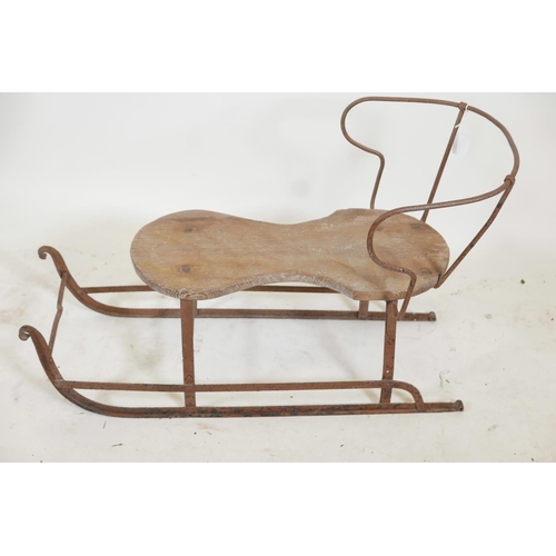 1174 - An antique child's sled, wrought iron with a wood seat, 32